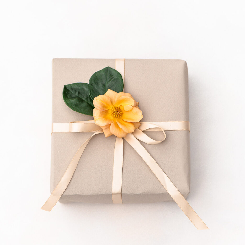 Gift wrapping with recyclable paper, reusable ribbon and flowers
