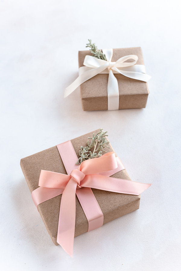 Eco friendly Christmas gift wrapping with recyclable craft paper, reusable ribbons and leaves